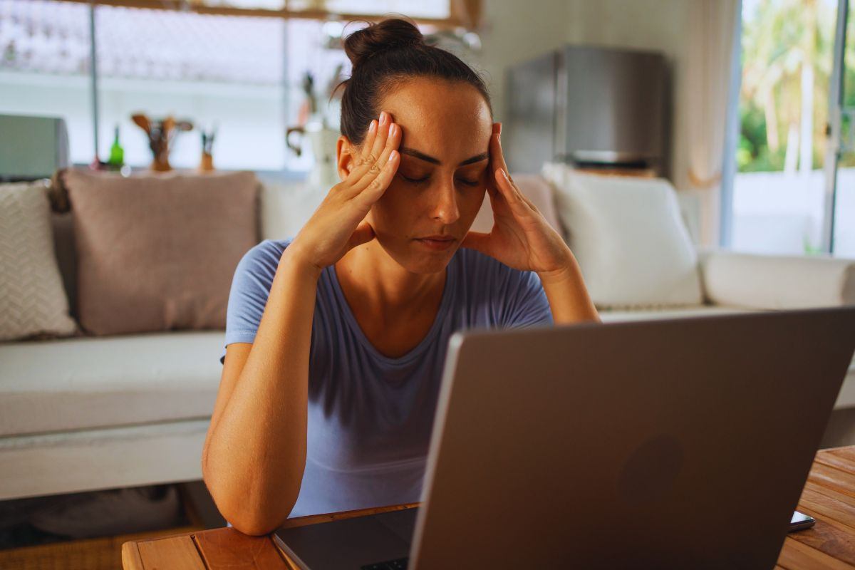 Donna stressata che si massaggia le tempie